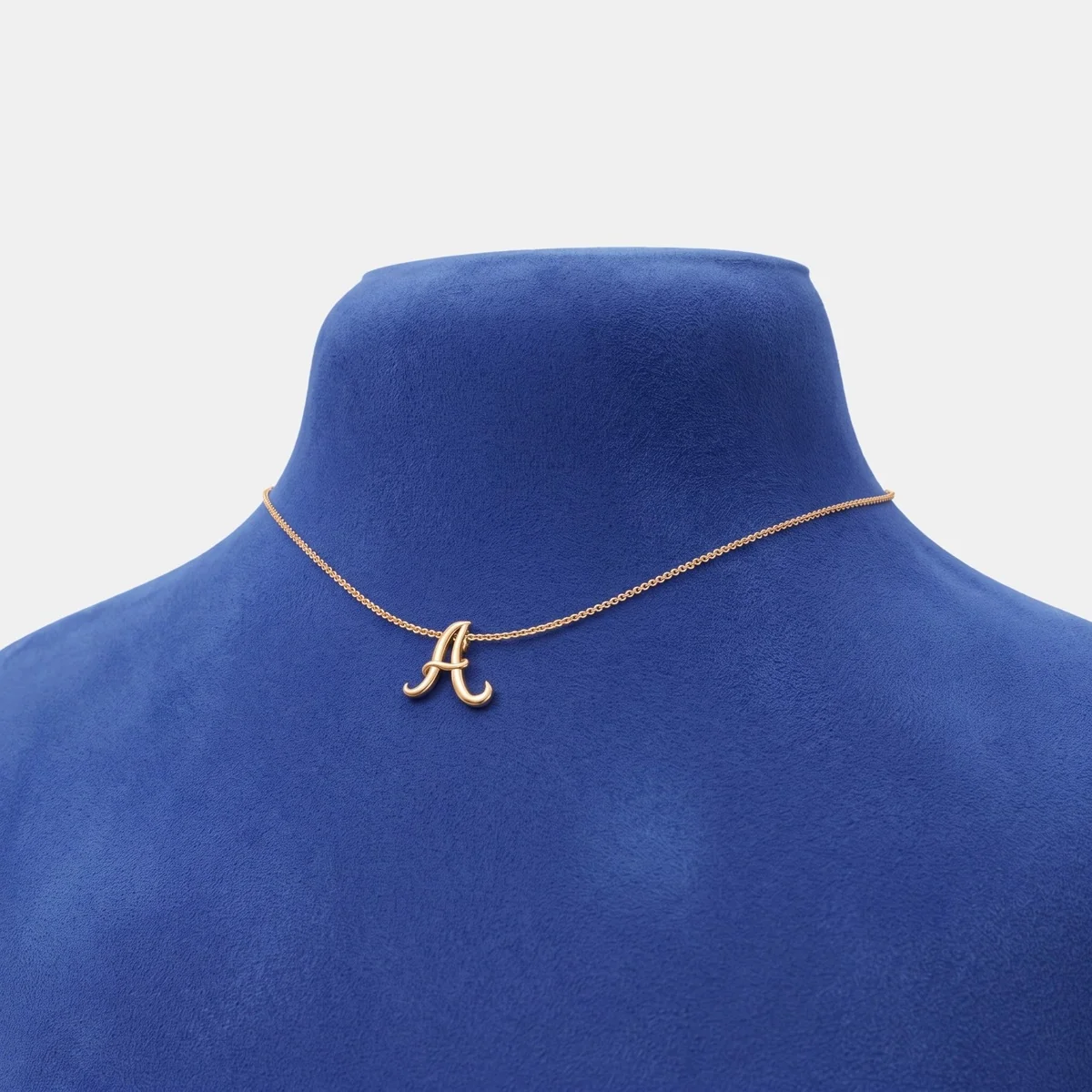 Inicial cursiva en oro amarillo, puesto en un busto
